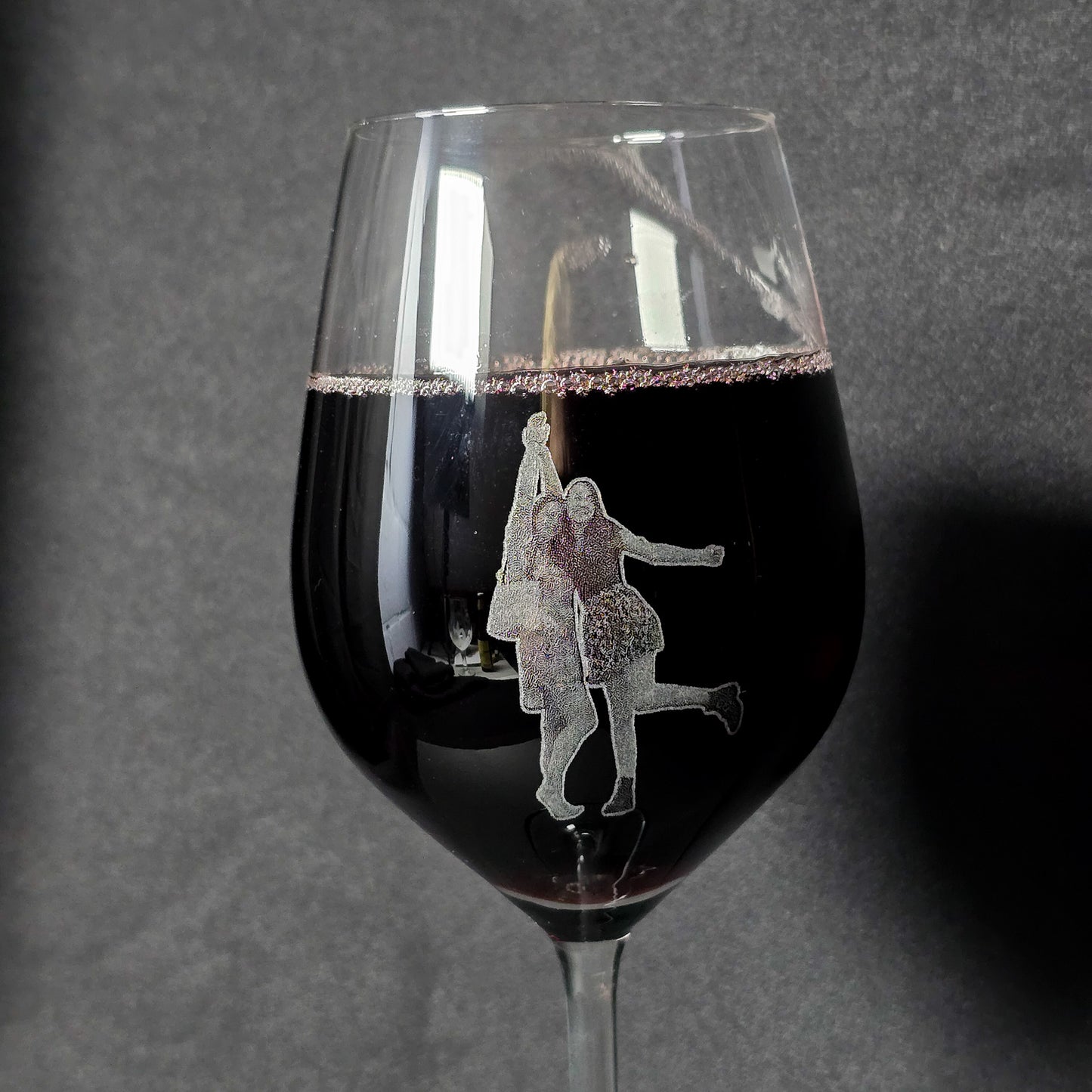 wijnglas waarop een gegraveerde foto staat van twee jonge dames