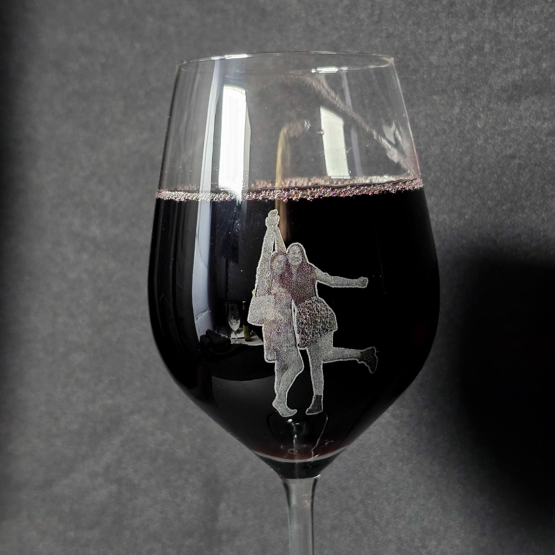 wijnglas waarop een gegraveerde foto staat van twee jonge dames